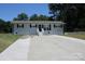 Newly renovated ranch home with a large concrete driveway and a well-manicured lawn at 4230 Northaven Dr, Charlotte, NC 28206