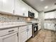 Updated kitchen with white cabinets, granite countertops, and stainless steel appliances at 4230 Northaven Dr, Charlotte, NC 28206