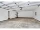 Spacious two car garage with lighting, a utility door and opener, and a large empty floor at 6169 Long Branch Rd, Salisbury, NC 28147