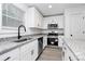 Well-lit kitchen boasts white cabinets, granite counters, and stainless appliances, with a black faucet adding contrast at 6169 Long Branch Rd, Salisbury, NC 28147