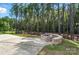 Outdoor stone fire pit with a curved retaining wall for seating amidst tall trees at 2024 Cedar Falls Dr # 9, Waxhaw, NC 28173
