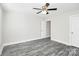 Empty bedroom featuring a ceiling fan, a window, and a door to a hallway at 6187 Long Branch Rd, Salisbury, NC 28147