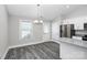 Bright dining area featuring a modern chandelier, stainless steel fridge and gray flooring at 6187 Long Branch Rd, Salisbury, NC 28147