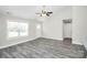 Spacious living room showcasing modern gray floors, large windows, and a ceiling fan at 6187 Long Branch Rd, Salisbury, NC 28147