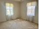 Bright bedroom with neutral walls, carpet flooring, and large windows dressed in sheer curtains at 2310 Montford Nw Ave, Concord, NC 28027