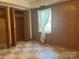 Bedroom featuring checkerboard flooring, wood paneled walls, and a built in closet at 2310 Montford Nw Ave, Concord, NC 28027