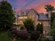 Stone chateau with manicured landscaping at dusk at 4536 Fox Brook Ln, Charlotte, NC 28211