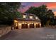 Three-car garage with stone exterior and lighting at 4536 Fox Brook Ln, Charlotte, NC 28211