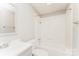 This white bathroom features a tub and shower combination with a single sink vanity at 1600 Sharon W Rd # 11, Charlotte, NC 28210