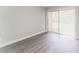 This light and airy bedroom features sliding glass doors to the outside and gray wood floors at 1600 Sharon W Rd # 11, Charlotte, NC 28210