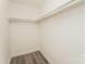 A closet is equipped with flooring, lighting, and bars for hanging at 1600 Sharon W Rd # 11, Charlotte, NC 28210