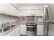 Updated kitchen features white cabinets, granite countertops, stainless steel appliances, and tiled floors at 1600 Sharon W Rd # 11, Charlotte, NC 28210