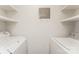 This small laundry room features a washer, a dryer, and shelving for storage at 1600 Sharon W Rd # 11, Charlotte, NC 28210