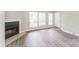 This living room features a fireplace, large windows, hardwood floors and a white front door at 1600 Sharon W Rd # 11, Charlotte, NC 28210