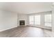 This living room features a corner fireplace, hardwood floors, and an abundance of natural light from the windows at 1600 Sharon W Rd # 11, Charlotte, NC 28210