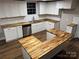Bright kitchen features white cabinets, butcher block counters, stainless appliances, and subway tile backsplash at 702 N 9Th St, Bessemer City, NC 28016
