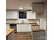 Kitchen area with white cabinets, butcher block counters, stainless appliances, and backsplash at 702 N 9Th St, Bessemer City, NC 28016