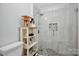 Modern bathroom with glass shower, pebble floor, and built-in shelf at 5003 Sharon Rd # L, Charlotte, NC 28210