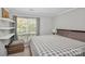 Spacious bedroom with large window, floating shelves, and king-size bed at 5003 Sharon Rd # L, Charlotte, NC 28210