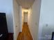 Well-lit hallway with wood floors, white walls, and multiple doorways at 927 Kearney Dr, Shelby, NC 28152