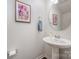 Small powder room with pedestal sink and circular mirror at 8053 Cornhill Ave, Charlotte, NC 28277