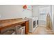 Bright laundry room with washer, dryer, and built-in shelving at 4043 Orchid Way, Tega Cay, SC 29708