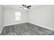 A neutral bedroom features a ceiling fan, gray tone wood flooring, and a window at 6217 Long Branch Rd, Salisbury, NC 28147