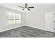 Well-lit bedroom features gray tone wood flooring, a ceiling fan, and a window at 6217 Long Branch Rd, Salisbury, NC 28147