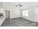 Bright living room features a vaulted ceiling, gray laminate flooring, and a modern ceiling fan at 6217 Long Branch Rd, Salisbury, NC 28147