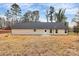 Image shows the home's backyard with its vinyl siding, black roof, and small concrete porch at 6259 Long Branch Rd, Salisbury, NC 28147