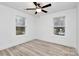 Neutral bedroom featuring a ceiling fan, two windows, and light wood laminate flooring at 6259 Long Branch Rd, Salisbury, NC 28147