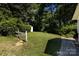 A spacious backyard provides ample greenery, complemented by trees and a wooden fence at 2001 Mcdonald Dr, Charlotte, NC 28216