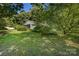 Backyard featuring green grass, a shed, and abundant shade from mature trees at 2001 Mcdonald Dr, Charlotte, NC 28216