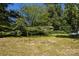 Green backyard featuring a small storage shed, mature trees, and a treehouse at 2001 Mcdonald Dr, Charlotte, NC 28216