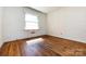 Bright bedroom featuring hardwood floors, wallpaper, and a window for natural light at 2001 Mcdonald Dr, Charlotte, NC 28216