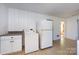 Bright kitchen with white appliances, white cabinets, countertops, and a washer/dryer at 2001 Mcdonald Dr, Charlotte, NC 28216