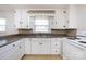 Bright kitchen featuring white cabinets, a double sink, and tile countertops at 2001 Mcdonald Dr, Charlotte, NC 28216