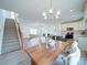 Dining room with a wood table and white chairs, offering an open view of the kitchen and living room at 2613 Plyler Mill Rd, Monroe, NC 28112