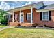 Brick home with a large front porch and American flag at 2909 Eastway Dr, Statesville, NC 28625