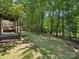 Picturesque backyard with a covered porch, serene wooded backdrop, and sprawling green lawn at 927 Dericks Xing, Fort Mill, SC 29708