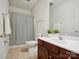 Well-lit bathroom featuring a dark wood vanity, large mirror, and a shower-tub combo with tiled flooring at 927 Dericks Xing, Fort Mill, SC 29708