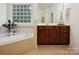 Bright bathroom features a garden tub, a window, and dark wood cabinets at 927 Dericks Xing, Fort Mill, SC 29708