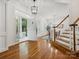 Bright foyer with hardwood floors, an elegant chandelier, and a staircase with white railings at 927 Dericks Xing, Fort Mill, SC 29708