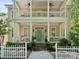 Inviting front porch with rocking chairs, a teal front door, brick stairs, and white columns at 927 Dericks Xing, Fort Mill, SC 29708