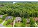 Aerial view of a beautiful home nestled among mature trees in a serene community near a lake at 160 Northington Woods Dr, Mooresville, NC 28117