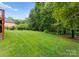 Expansive backyard lawn area, partially shaded by mature trees, perfect for outdoor activities and relaxation at 160 Northington Woods Dr, Mooresville, NC 28117