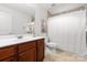 Well-lit bathroom featuring cherry cabinet, white countertops and a shower with white curtain at 160 Northington Woods Dr, Mooresville, NC 28117