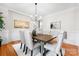 Elegant dining room featuring hardwood floors, wainscoting, stylish chandelier, and ample seating at 160 Northington Woods Dr, Mooresville, NC 28117