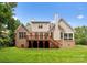 A view of the back of the home with a wooden deck overlooking a large grassy yard at 160 Northington Woods Dr, Mooresville, NC 28117