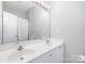 A bright bathroom with double sinks, a large mirror, and a shower with white curtain at 12229 Savannah Garden Dr, Charlotte, NC 28273